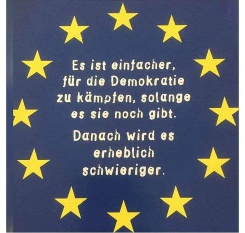 Die Europaflagge, darauf steht :
Es ist einfacher, für die Demokratie zu kämpfen, solange es sie noch gibt.

Danach wird es erheblich schwieriger.